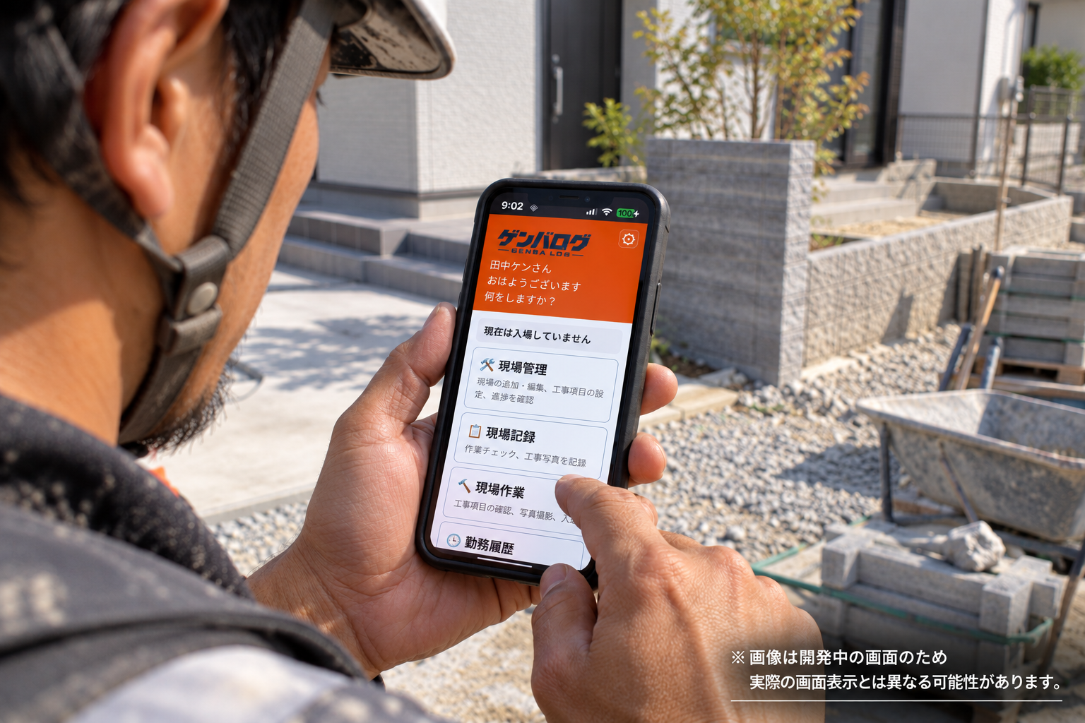 建設現場でゲンバログのホーム画面を確認する職人